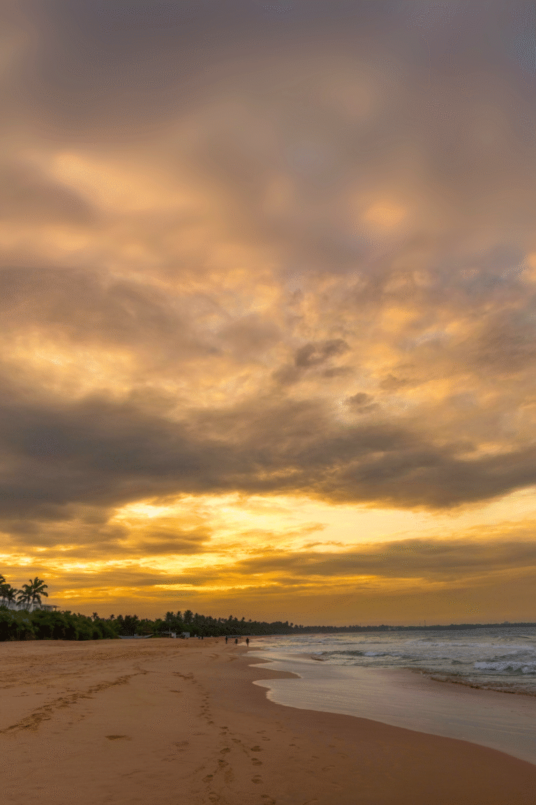 Golden sandy beach of Bentota under a vibrant sunset sky in Sri Lanka