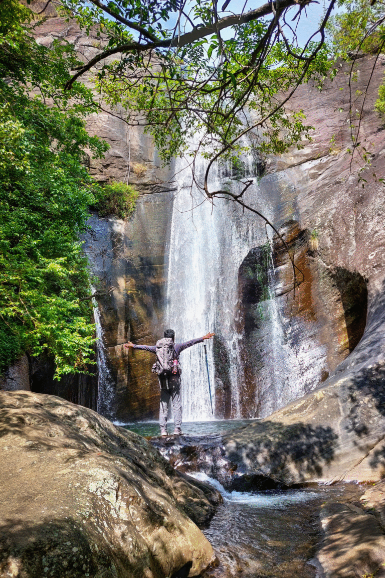 Tourist admiring the beauty of Lanka Ella Waterfall on a sunny day