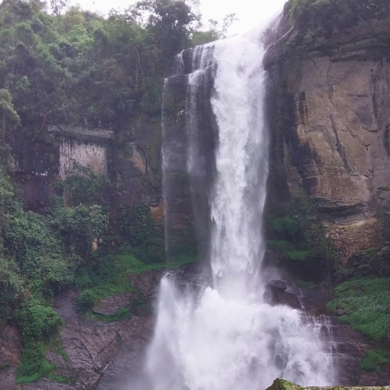 Tall waterfall surrounded by lush greenery in Ramboda