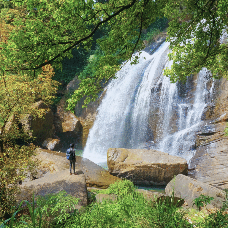 Huluganga waterfall flowing through lush greenery in Sri Lanka