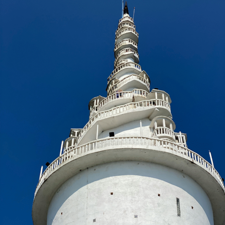 White Ambuluwawa stupa rising above lush green hills