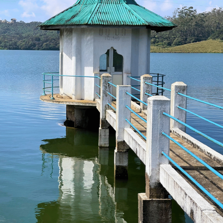 Calm lake surface of Kande Ela surrounded by tea plantations