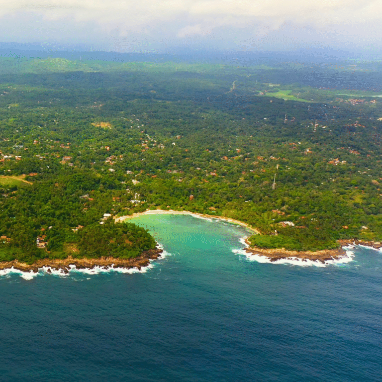 Aerial view of Hiriketiya Beach surrounded by tropical greeneryAerial view of Hiriketiya Beach surrounded by tropical greenery