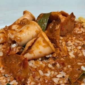 Cuttlefish curry garnished with curry leaves and spices